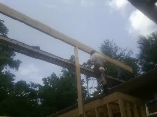 Carpenter setting a ridge beam over a new addition frame — Ice Dam Removal by Roofing Brothers in Dillsburg