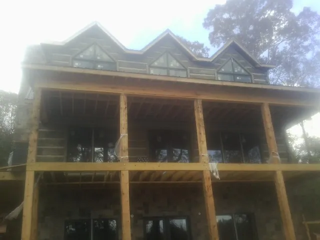 Dormers and porch framing on a large log home under construction — Roof Coating work by our crew in Dillsburg